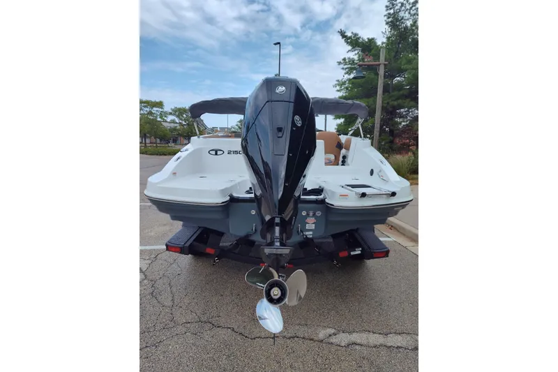 Slide: The Image of 2027 Tahoe 2150 boat rear view with outboard motor in parking lot. - 16