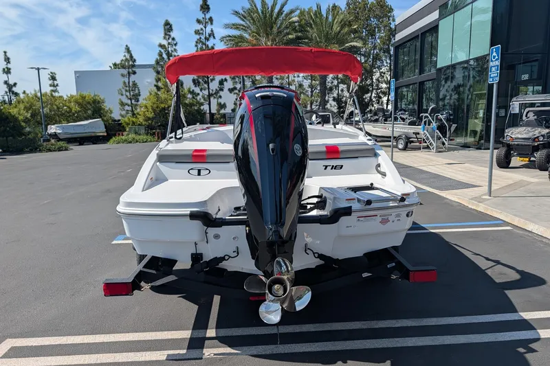 Slide: The Image of 2027 Tahoe T18 boat with outboard motor, parked outdoors near modern building. - 5