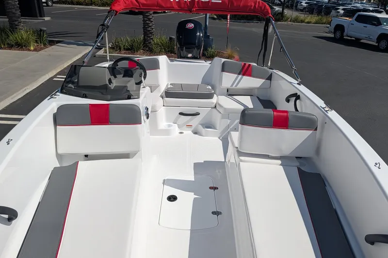 Slide: The Image of 2027 Tahoe T18 boat interior with red and gray seating, parked outdoors. - 7