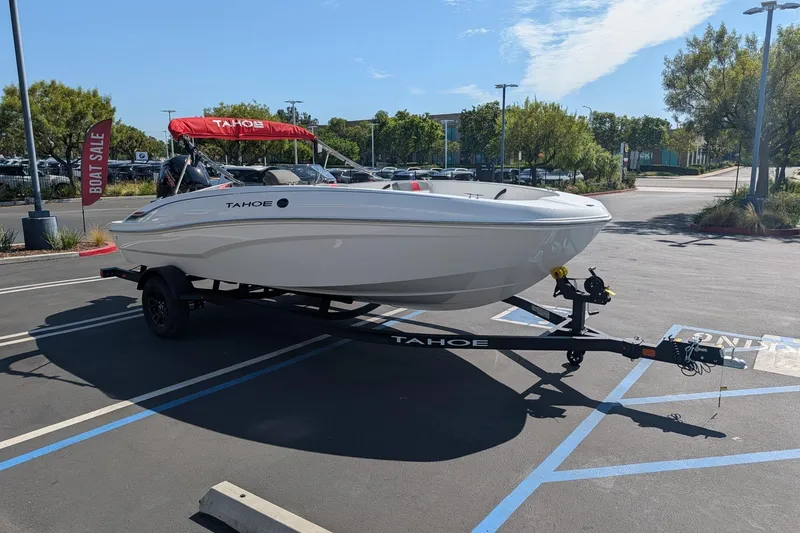 Slide: The Image of 2027 Tahoe T18 boat on trailer in parking lot, boat sale sign visible. - 1