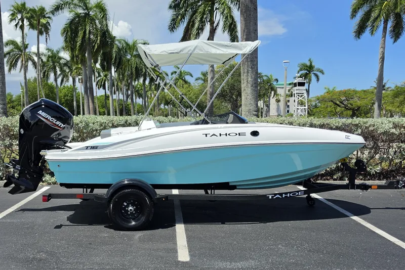 Slide: The Image of 2027 Tahoe T16 boat with canopy on trailer, parked under palm trees. - 1