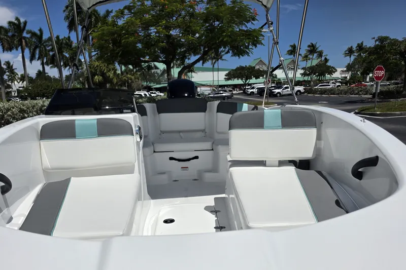 Slide: The Image of 2027 Tahoe T16 boat interior with white and gray seating, parked outdoors. - 4