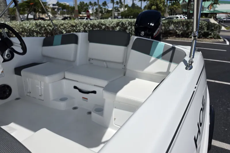 Slide: The Image of 2027 Tahoe T16 boat interior with cushioned seating and steering wheel, parked outdoors. - 5