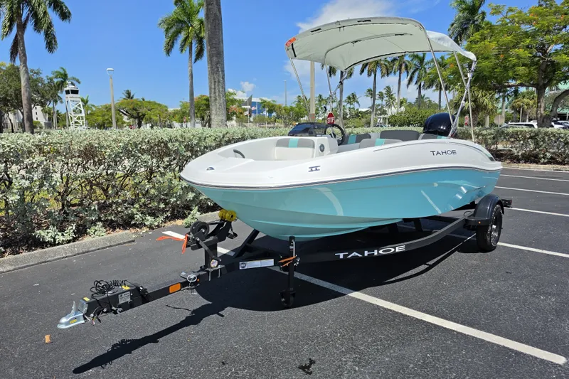 Slide: The Image of 2027 Tahoe T16 boat on trailer in sunny parking lot with palm trees. - 2