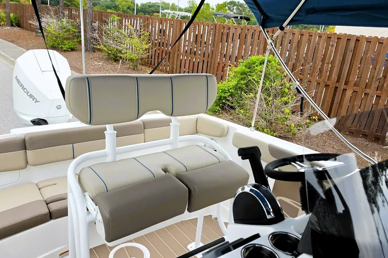 Slide: The Image of 2027 Tahoe 2150 CC boat interior with seating and steering wheel, featuring a Mercury engine. - 13