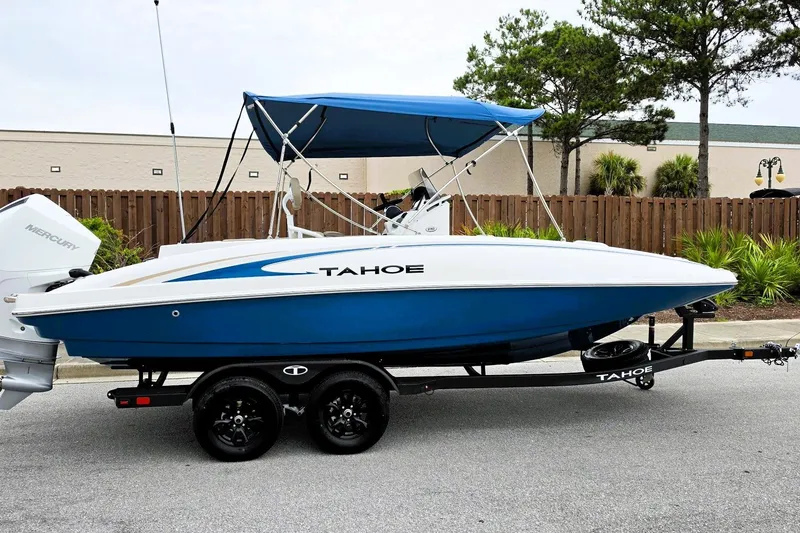 The Image of 2027 Tahoe 2150 CC boat with blue hull and canopy on trailer. - 0