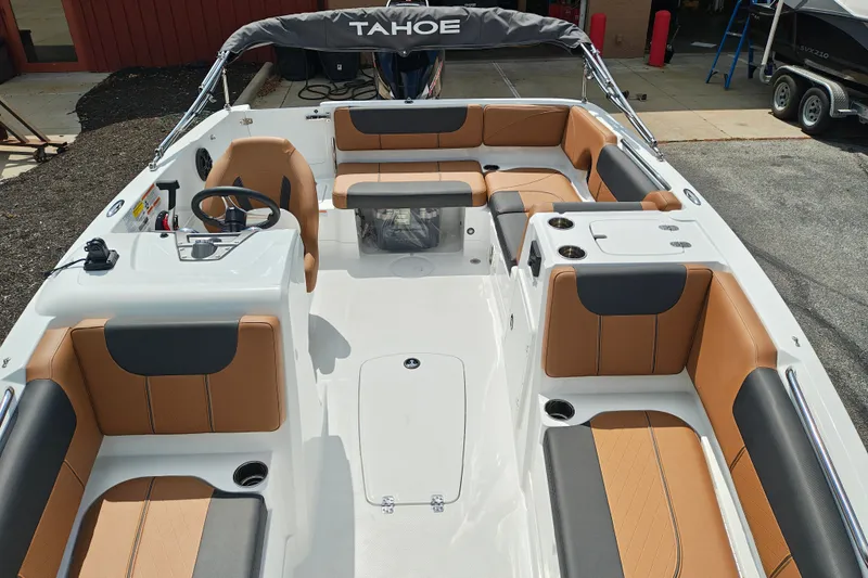 Slide: The Image of 2027 Tahoe 1950 boat interior with tan and black seating, steering wheel, and cup holders. - 141