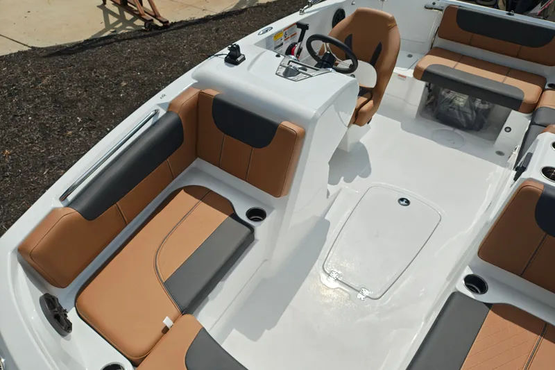 Slide: The Image of 2027 Tahoe 1950 boat interior with tan and black seating, steering console, and cup holders. - 143