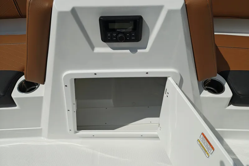 Slide: The Image of 2027 Tahoe 1950 boat interior with open storage compartment and audio system. - 130