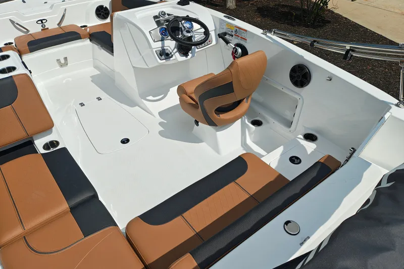 Slide: The Image of 2027 Tahoe 1950 boat interior with brown and black seating, steering console, and cup holders. - 118