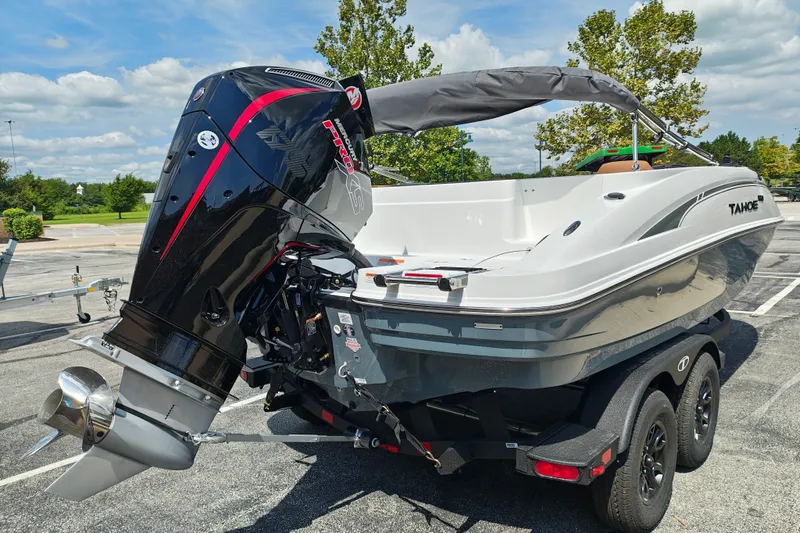 Slide: The Image of 2027 Tahoe 1950 boat with powerful outboard motor on trailer in sunny parking lot. - 113