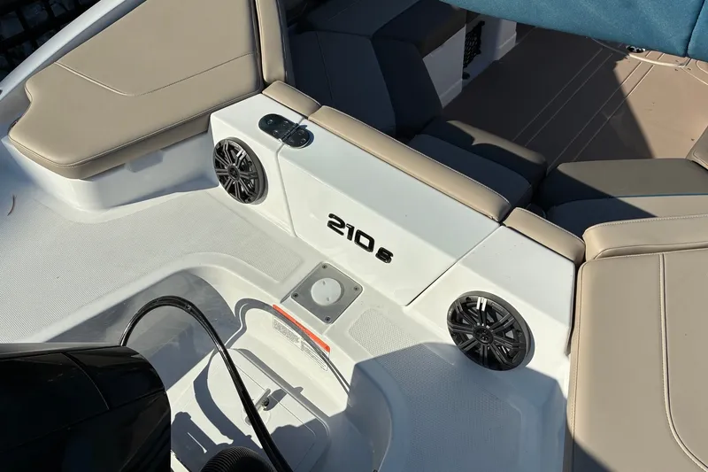 Slide: The Image of Interior of 2027 Tahoe 210 S boat with beige seating and speakers. - 17