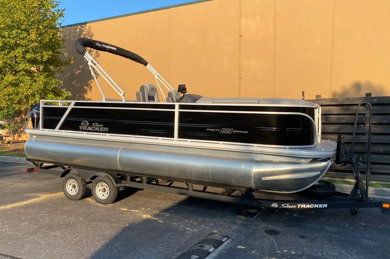 The Image of 2026 Sun Tracker Party Barge 22 RF DLX pontoon boat on trailer, parked outdoors. - 0