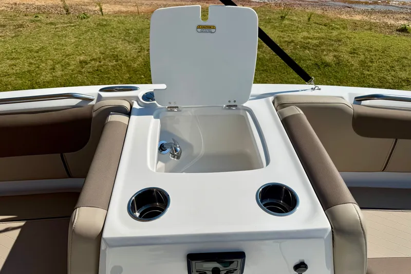 Slide: The Image of 2027 Tahoe 2150 boat interior with open storage compartment and cup holders. - 16