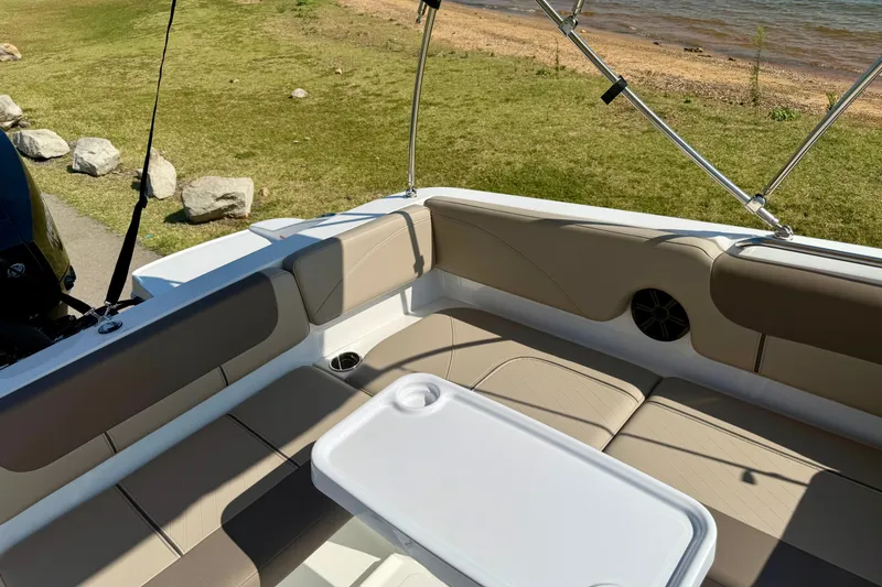 Slide: The Image of Interior of 2027 Tahoe 2150 boat with seating and table by a lakeside. - 13
