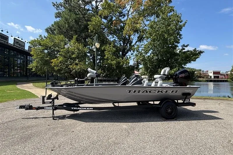 The Image of 2027 Tracker Pro Team 195 boat on trailer, parked near a scenic lake. - 0