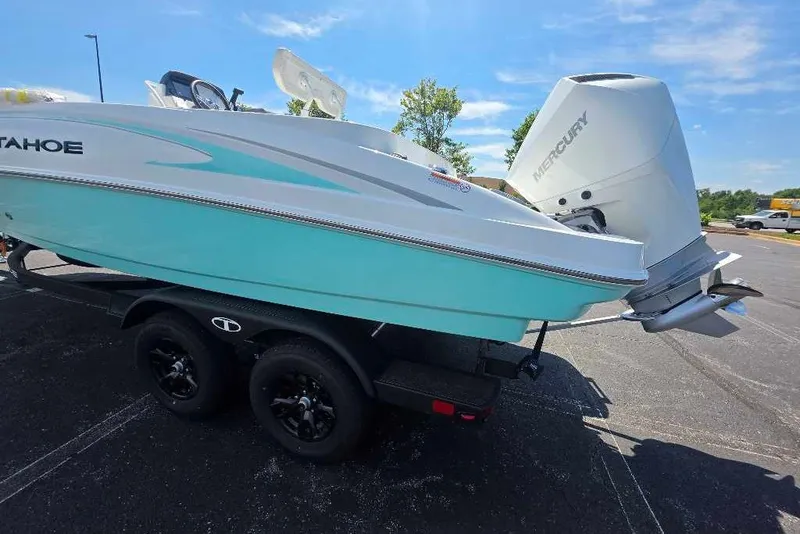Slide: The Image of 2027 Tahoe 2150 CC boat with Mercury engine on trailer, parked outdoors. - 2