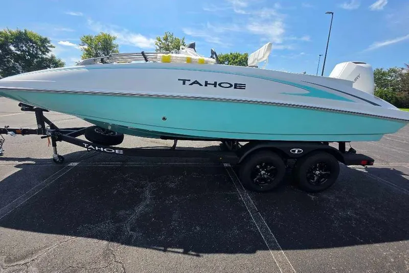 The Image of 2027 Tahoe 2150 CC boat on trailer, parked outdoors under clear blue sky. - 0
