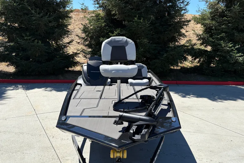 Slide: The Image of 2027 Tracker Pro 170 boat parked on concrete, surrounded by trees. - 13