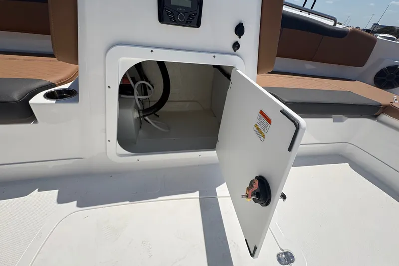 Slide: The Image of Open storage compartment on a 2027 Tahoe 2150 boat, featuring seating and cup holder. - 14