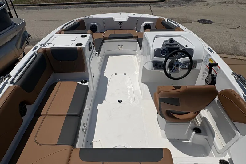Slide: The Image of 2027 Tahoe 2150 boat interior with brown seating and steering console. - 6