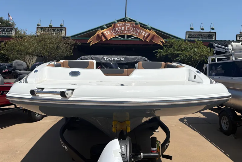 Slide: The Image of A white 2027 Tahoe 2150 boat on a trailer in front of a building. - 2
