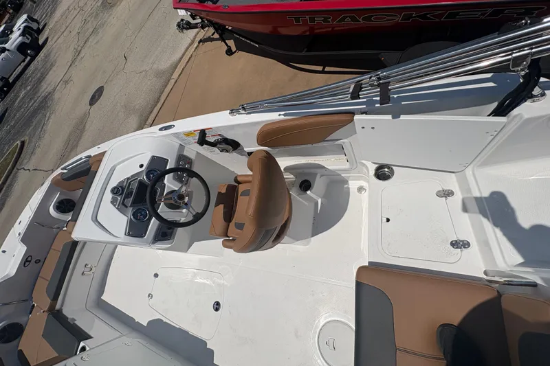 Slide: The Image of 2027 Tahoe 2150 boat interior with brown seating and steering console. - 8