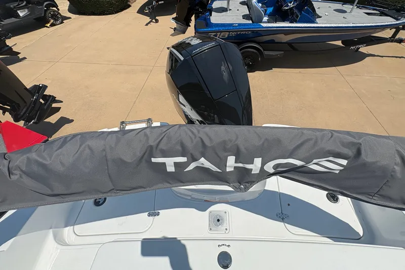 Slide: The Image of 2027 Tahoe 2150 boat with protective cover, displayed outdoors alongside other boats. - 7