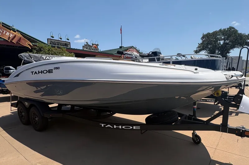 Slide: The Image of A white 2027 Tahoe 2150 boat is on a trailer in a parking lot. - 1