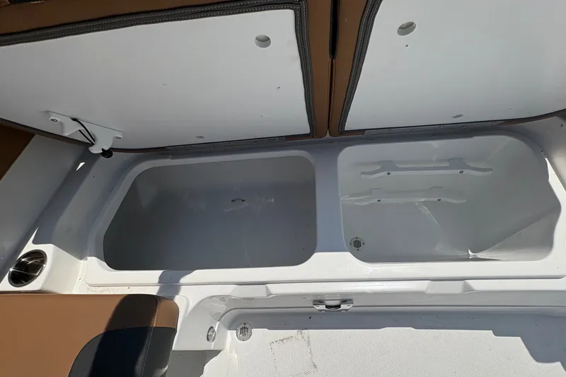 Slide: The Image of 2027 Tahoe 2150 boat storage compartments with white and brown interior design. - 11