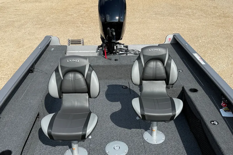 Slide: The Image of 2027 Lund 1875 Pro Guide boat interior with two gray seats and motor. - 9