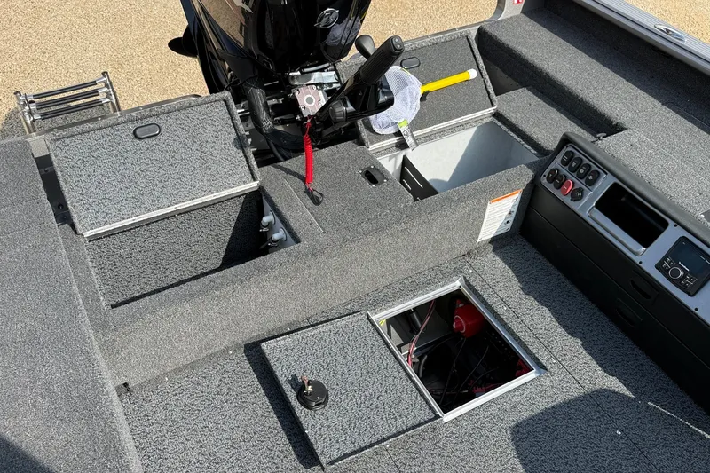 Slide: The Image of 2027 Lund 1875 Pro Guide boat interior with open storage compartments and control panel. - 15