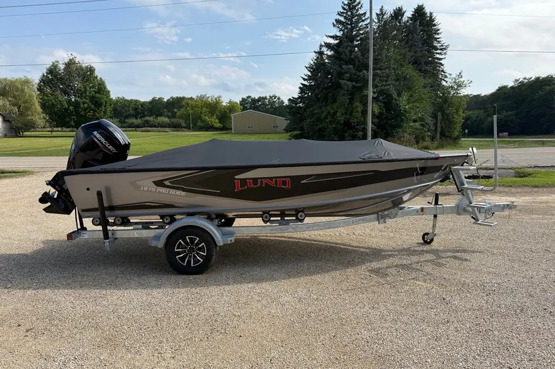 Slide: The Image of 2027 Lund 1875 Pro Guide boat on trailer, covered, with Mercury outboard motor. - 17