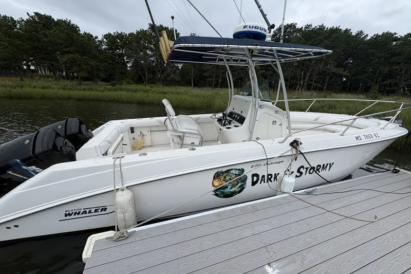 The Image of 2004 Boston Whaler 270 Outrage boat docked, featuring "Dark & Stormy" graphic. - 0