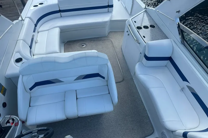 Slide: The Image of 2004 Formula 280 Sun Sport boat interior with white and blue seating, cup holders, and steering wheel. - 15
