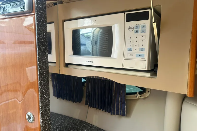Slide: The Image of Microwave in 2004 Formula 280 Sun Sport boat interior, featuring wood and granite finishes. - 28