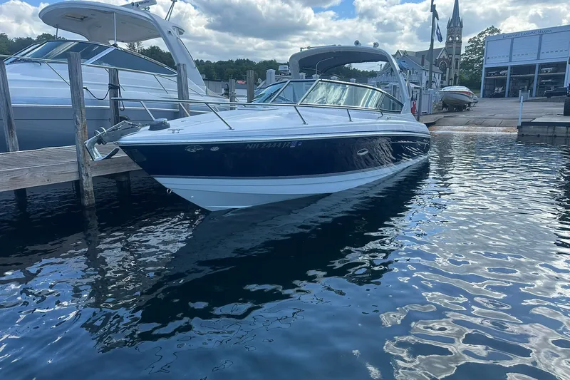 Slide: The Image of 2004 Formula 280 Sun Sport boat docked at a marina, reflecting on the water. - 1