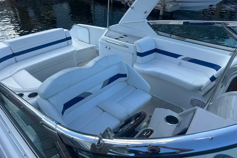 Slide: The Image of 2004 Formula 280 Sun Sport boat interior with white and blue seating, docked by water. - 5