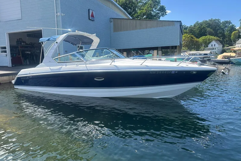 The Image of 2004 Formula 280 Sun Sport boat docked near a marina, blue and white exterior. - 0