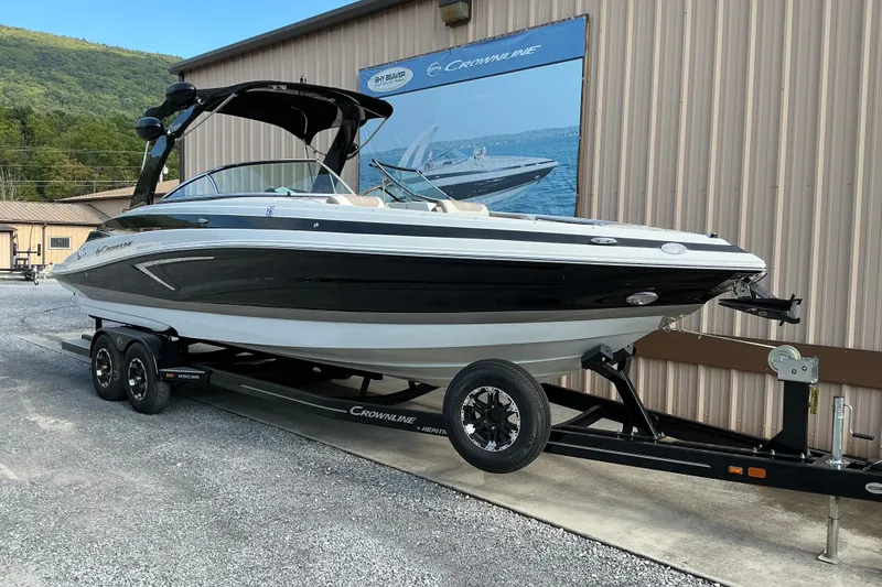 Slide: The Image of 2020 Crownline 290 SS boat on trailer, parked outside a building. - 1