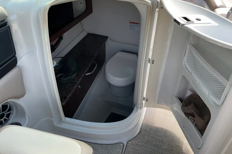 Slide: The Image of 2020 Crownline 290 SS boat interior with compact bathroom and modern amenities. - 9