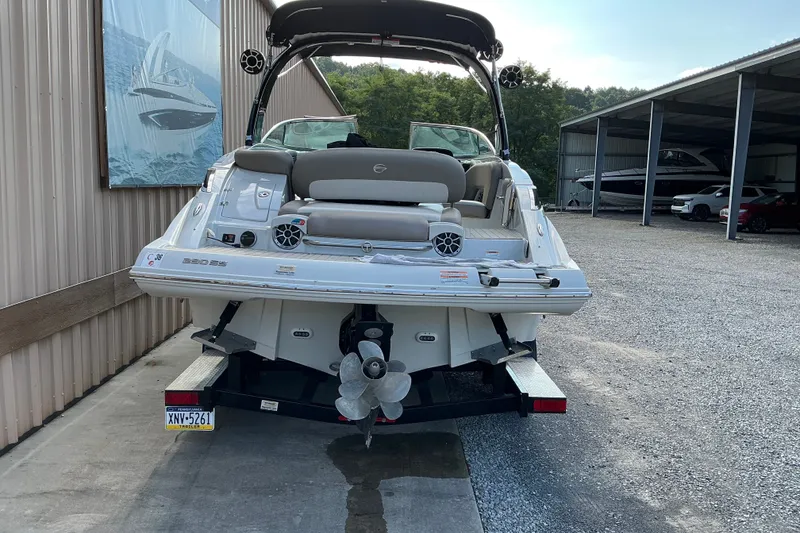 Slide: The Image of 2020 Crownline 290 SS boat on trailer, parked near storage facility. - 2