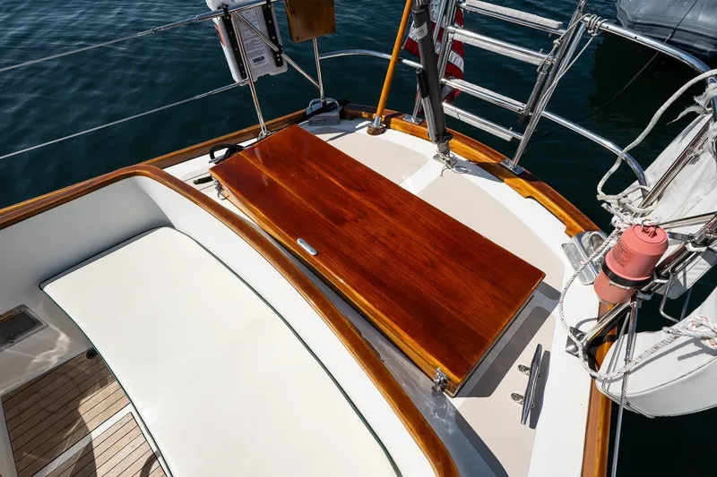 Slide: The Image of Hinckley Sou'wester 42 sailboat deck, featuring polished wood and white seating, 1987 model. - 17