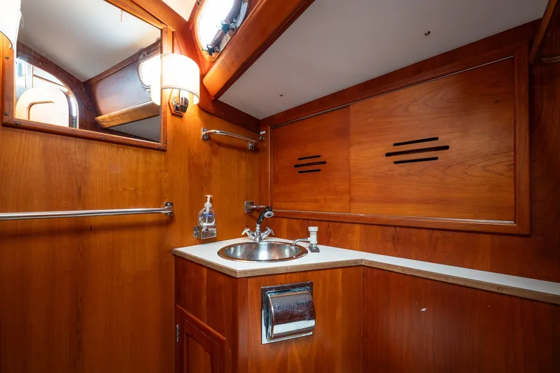 Slide: The Image of 1987 Hinckley Sou'wester 42 yacht bathroom with wooden cabinetry and stainless steel sink. - 35