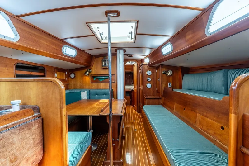 Slide: The Image of Interior of 1987 Hinckley Sou'wester 42 sailboat with wooden furnishings and teal seating. - 26