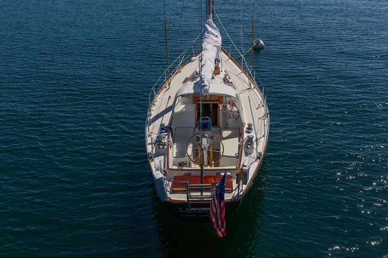 Slide: The Image of 1987 Hinckley Sou'wester 42 sailboat on calm blue water, rear view. - 48