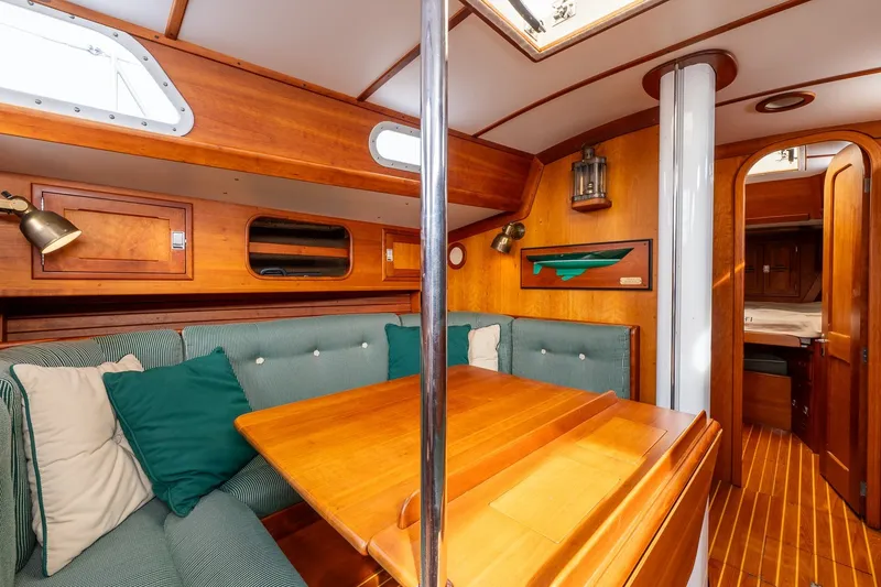 Slide: The Image of Cozy interior of 1987 Hinckley Sou'wester 42 sailboat with wooden furnishings and seating area. - 32