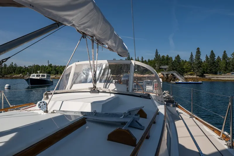Slide: The Image of 1987 Hinckley Sou'wester 42 sailboat docked in scenic harbor with clear blue sky. - 15