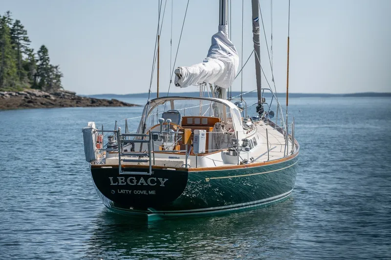 Slide: The Image of Hinckley Sou'wester 42 sailboat from 1987, named "Legacy," anchored in calm waters. - 2