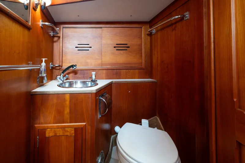 Slide: The Image of Hinckley Sou'wester 42 yacht bathroom, featuring wooden cabinetry and stainless steel sink, 1987 model. - 34